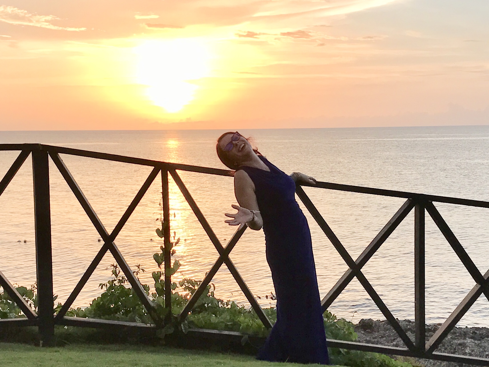Molley Marlena at sunset by the sea in a navy gown